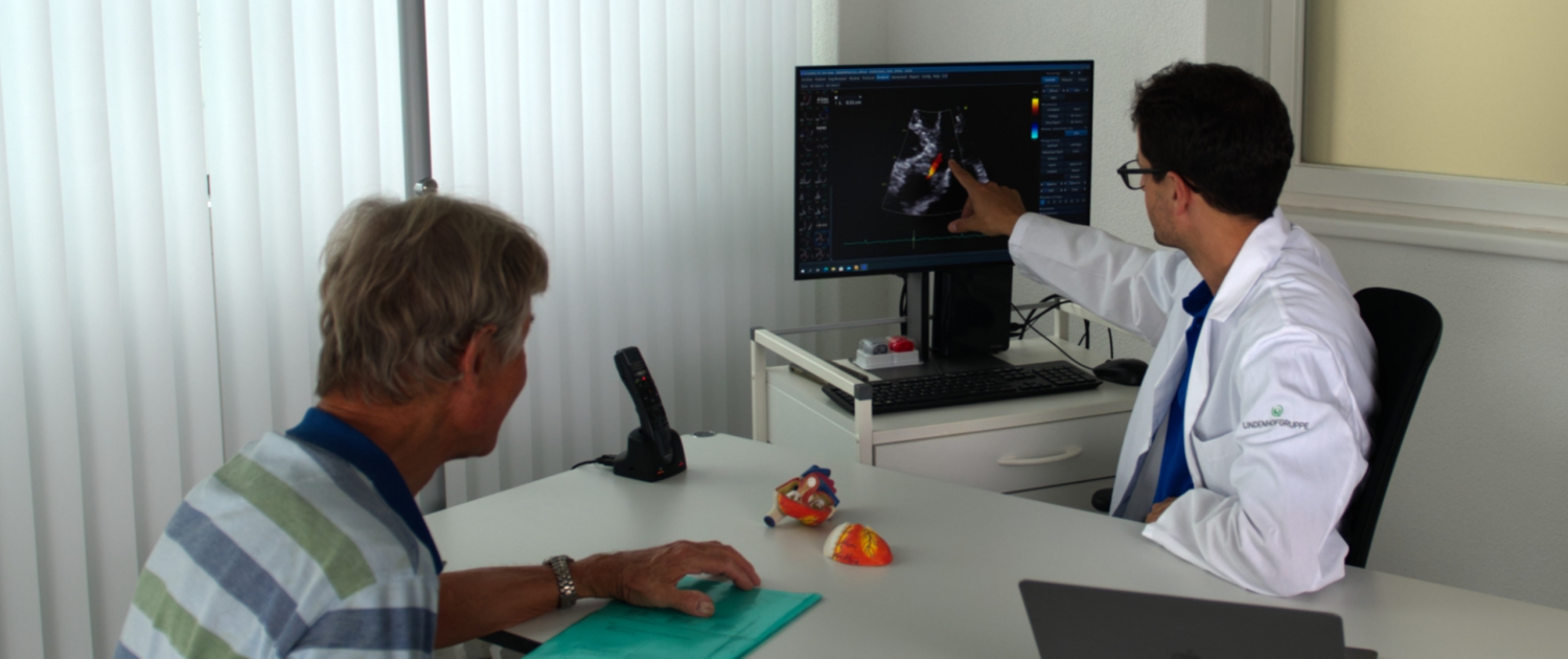 Dr. Andreas Indermühle bespricht ein Herzultraschall-Bild mit einem Patienten in der Herzpraxis Oberland in Spiez